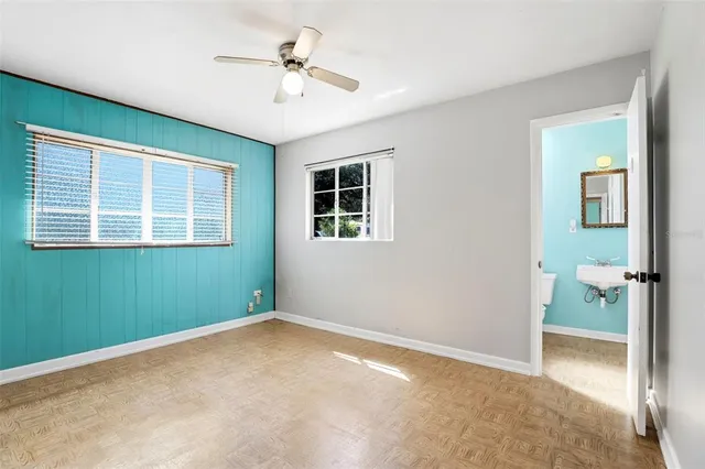 an empty room with a window and a ceiling fan