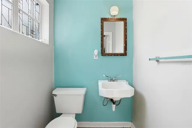 a bathroom with a toilet sink and mirror