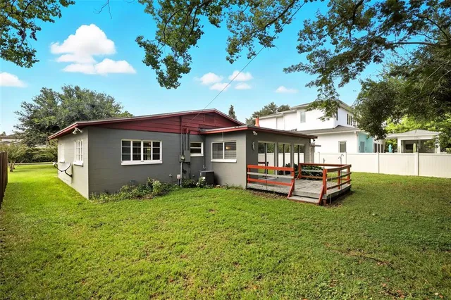 a view of a house with table and chairs under an umbrella