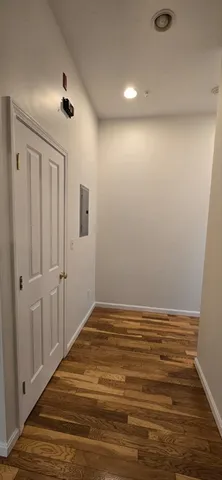 an empty room with wooden floor chandelier fan and windows