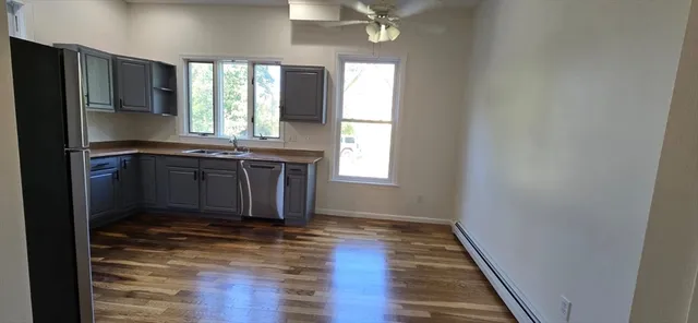 a kitchen with kitchen island granite countertop a sink cabinets and stainless steel appliances
