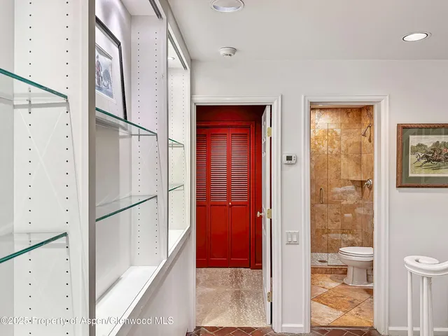 a view of a hallway with white walls and door