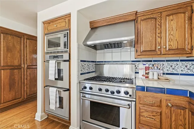 a kitchen with granite countertop a sink stove and cabinets