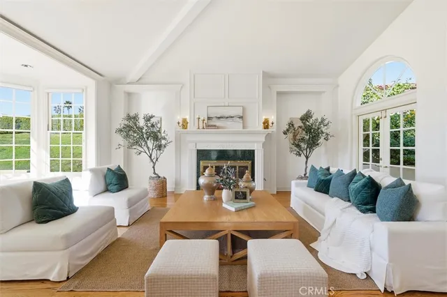 a living room with furniture a fireplace and a large window