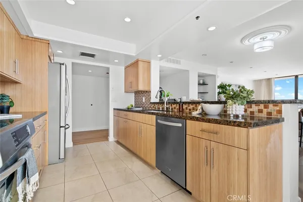 a kitchen with stainless steel appliances granite countertop a stove top oven microwave and refrigerator