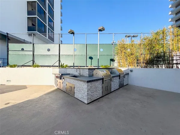 a roof deck with table and chairs and potted plants