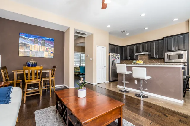 a living room with stainless steel appliances furniture a dining table with kitchen view