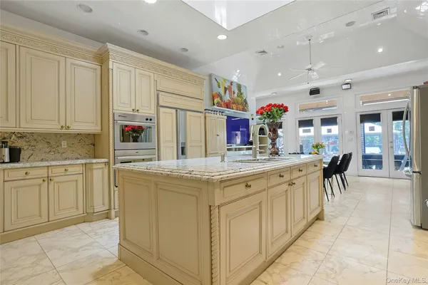 a kitchen with kitchen island granite countertop lots of white cabinets a sink and dishwasher