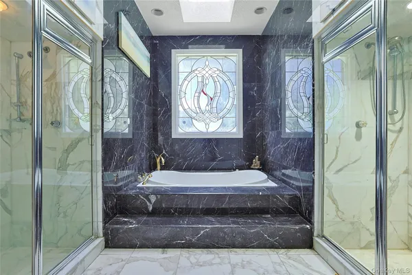 a bathroom with a tub shower and window