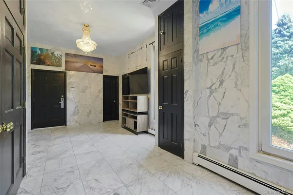 a view of a hallway with a cabinet and a mirror