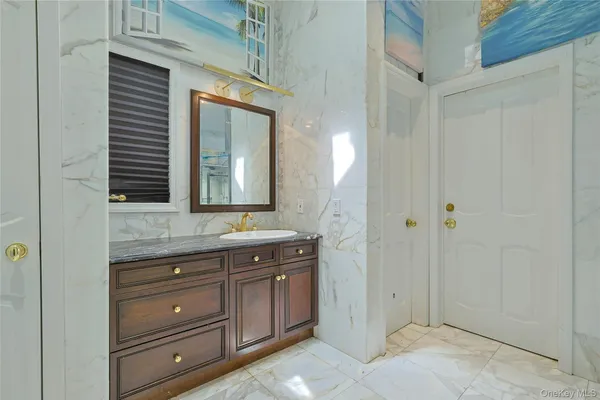 a bathroom with a granite countertop sink a mirror and a shower