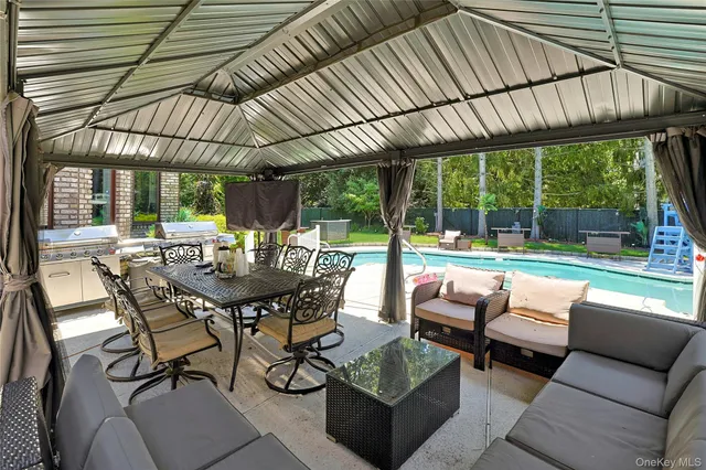 a view of a patio with couches table and chairs with potted plants