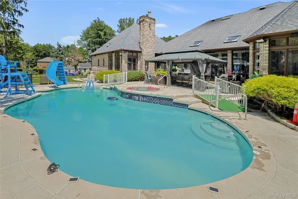 swimming pool view with a seating space and a garden