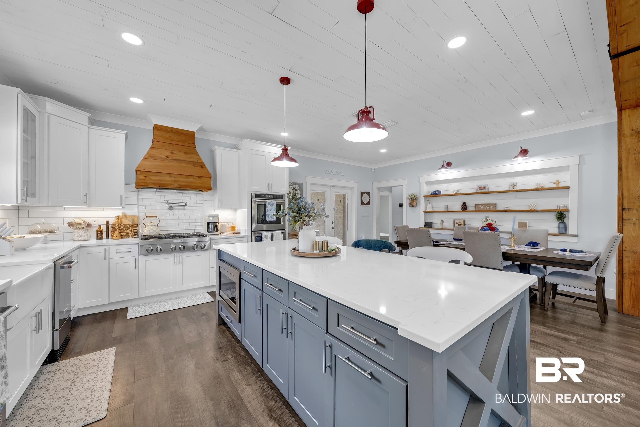 6576 Ranch Loop Road East Grand Bay, AL 36541 - Photo 15 of 39 Spacious kitchen featuring an expansive central island with a quartz countertop, custom blue cabinetry, and built-in microwave drawer