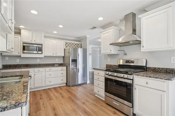 a kitchen with stainless steel appliances granite countertop a stove a sink and a refrigerator