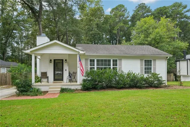 a front view of a house with a yard and trees