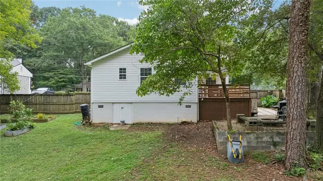 a view of a backyard with plants and large tree