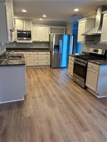 a kitchen with stainless steel appliances granite countertop a stove a sink and a refrigerator