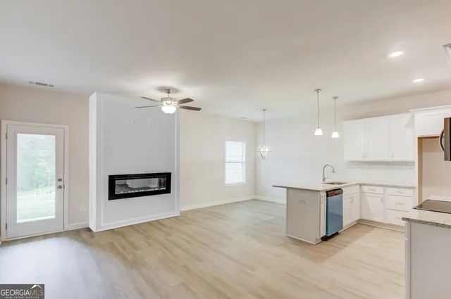 an empty room with windows and chandelier fan