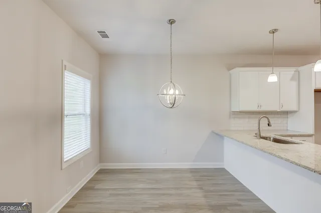 a kitchen with stainless steel appliances granite countertop a sink a stove and a granite counter top