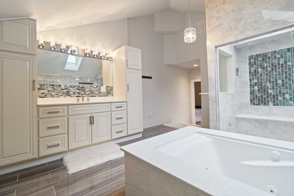 141 Gardiner Road Quincy, MA 02169 - Photo 20 of 39 a spacious bathroom with a granite countertop sink a mirror and a bathtub