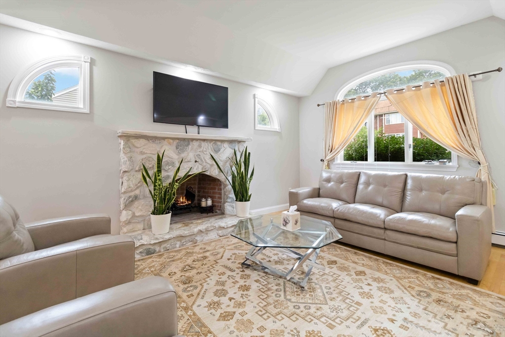 141 Gardiner Road Quincy, MA 02169 - Photo 6 of 39 a living room with furniture a flat screen tv and a fireplace