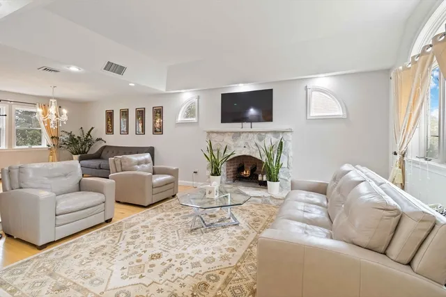 a living room with furniture a flat screen tv and a fireplace