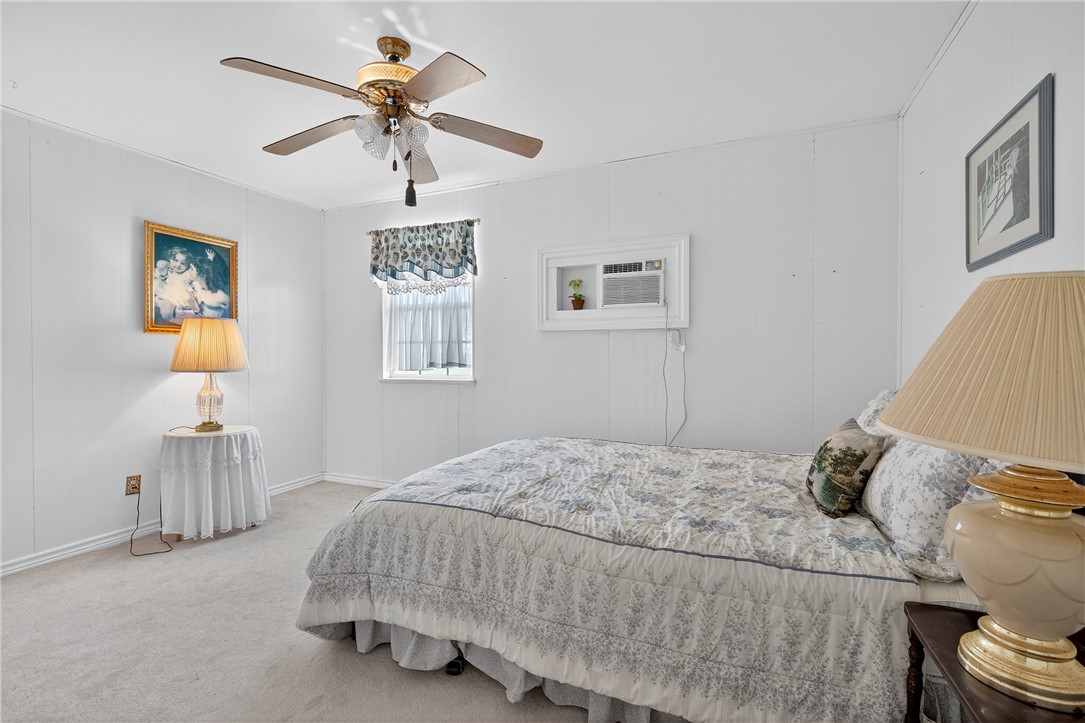 107 Lakefield Drive East Mathis, TX 78368 - Photo 18 of 33 a bedroom with a bed and a chandelier