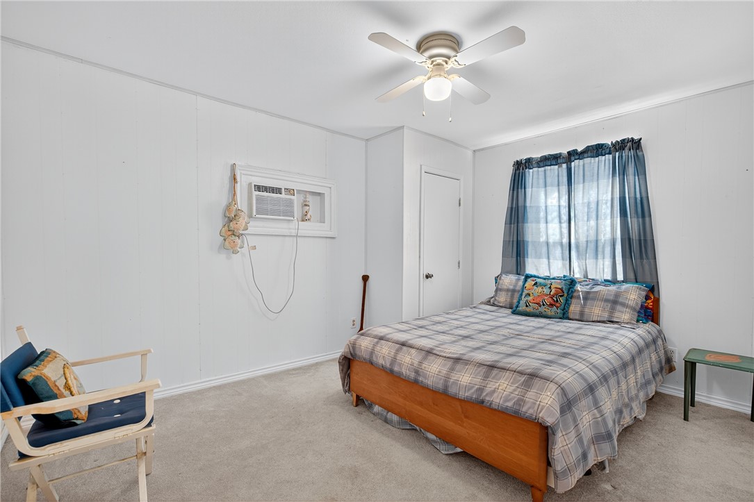 107 Lakefield Drive East Mathis, TX 78368 - Photo 19 of 33 a bedroom with a bed and a chandelier