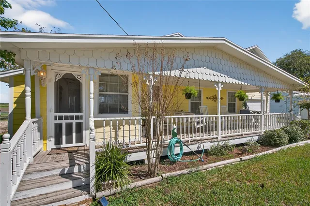 a view of a patio with lawn chairs floor to ceiling window and wooden floor
