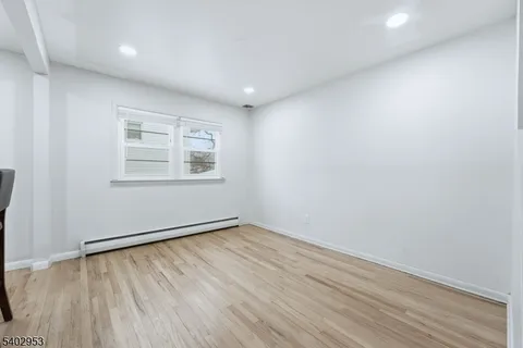 wooden floor fireplace and windows in an empty room