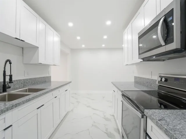 a metallic refrigerator freezer sitting in a kitchen