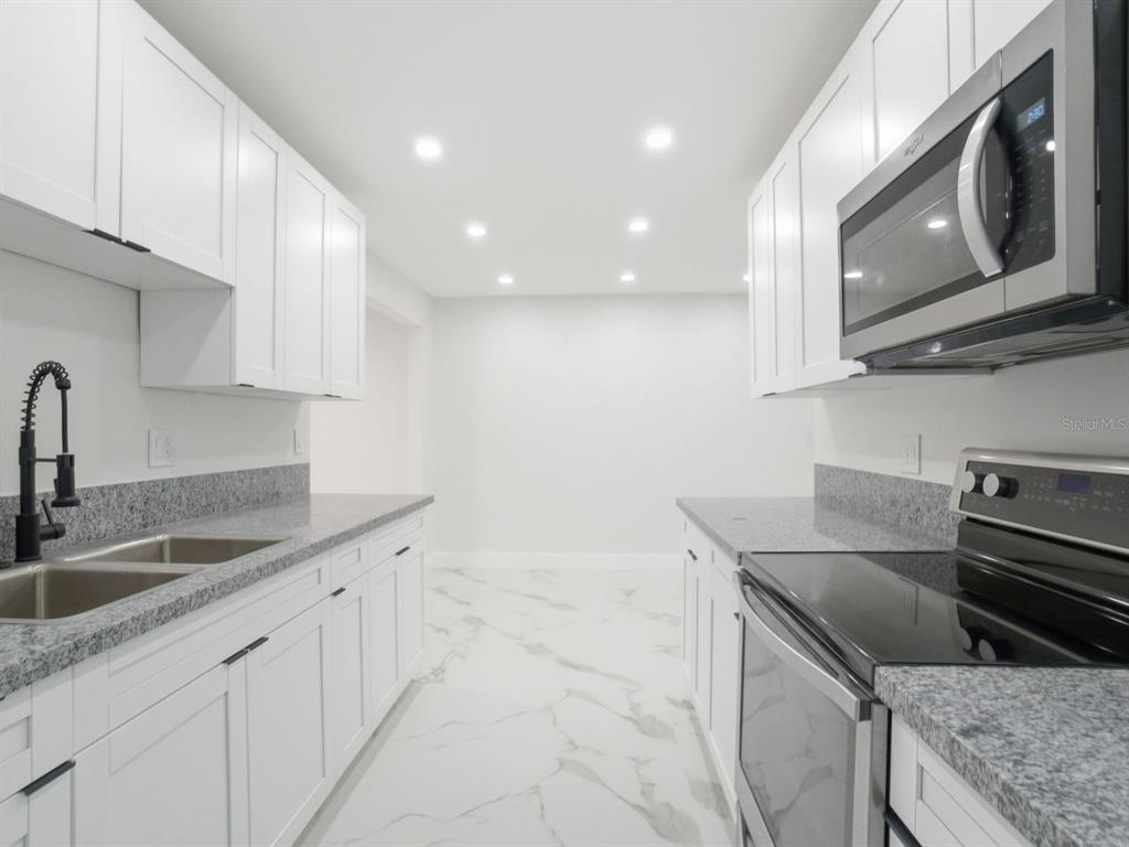 390 Hazel Circle Punta Gorda, FL 33982 - Photo 14 of 44 a kitchen with granite countertop a sink stainless steel appliances and cabinets