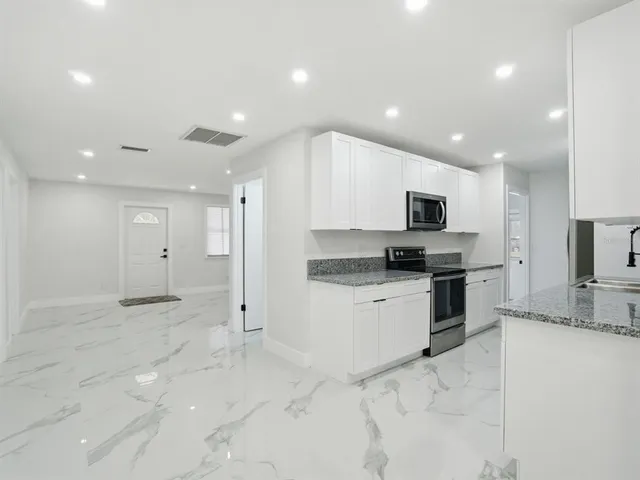 a modern kitchen with stainless steel appliances granite countertop a sink and a stove