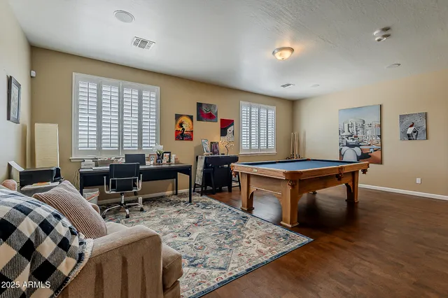 a living room with furniture a desk and chair with windows