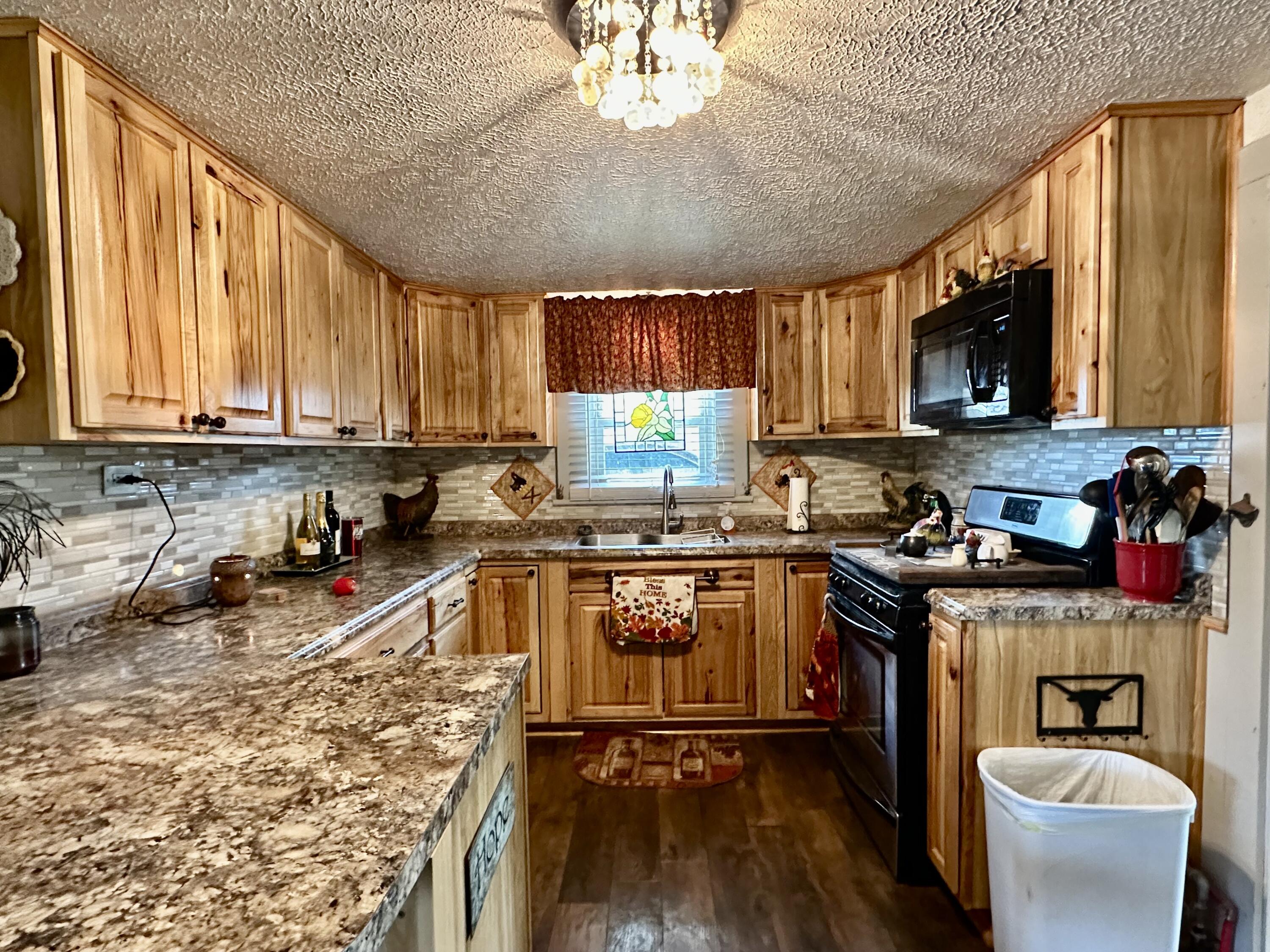 600 Mulberry Street Turkey, TX 79261 - Photo 15 of 29 a kitchen with a stove a sink and a microwave