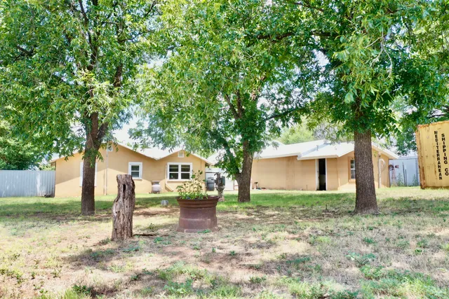 a white house that has a tree in front of it