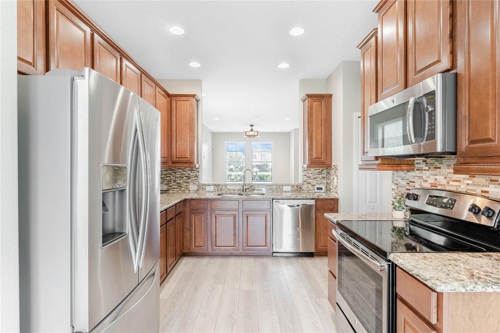 337 Partridge Pea Lane Ocoee, FL 34761 - Photo 11 of 38 a kitchen with stainless steel appliances granite countertop a refrigerator a stove and a sink