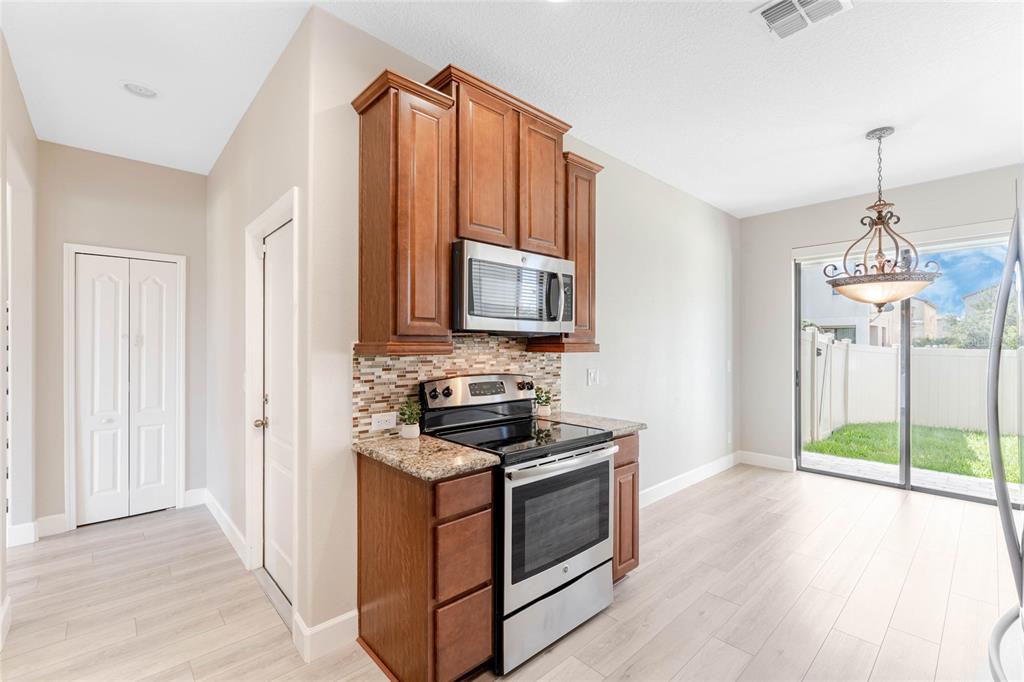 337 Partridge Pea Lane Ocoee, FL 34761 - Photo 13 of 38 a kitchen that has a stove and a wooden floor
