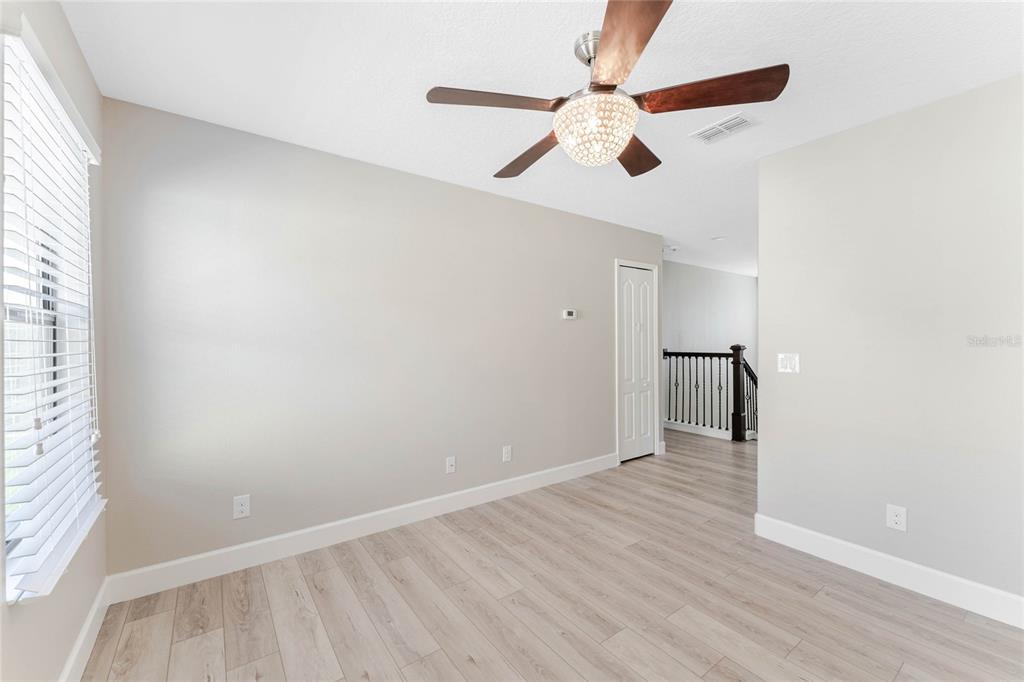 337 Partridge Pea Lane Ocoee, FL 34761 - Photo 26 of 38 an empty room with wooden floor fan and windows