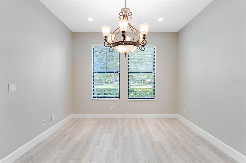 337 Partridge Pea Lane Ocoee, FL 34761 - Photo 7 of 38 an empty room with wooden floor chandelier and windows