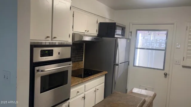 a kitchen with a refrigerator sink and cabinets