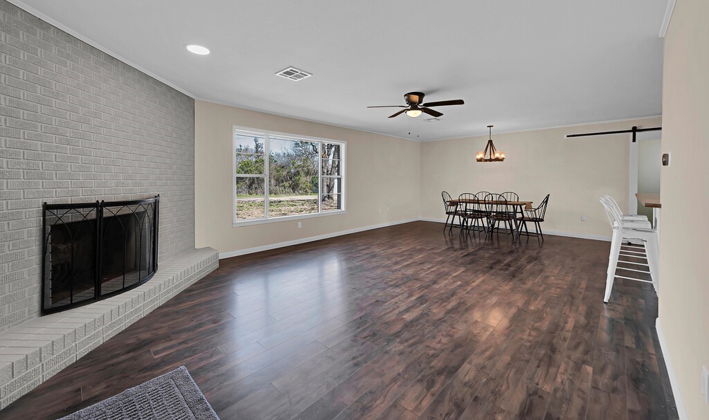 122 Teeling Trail Whitney, TX 76692 - Photo 11 of 31 an empty room with wooden floor fireplace and windows