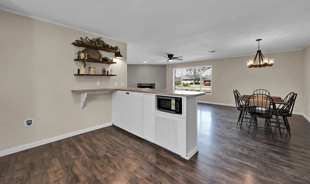 a kitchen with stainless steel appliances a dining table chairs and stove top oven