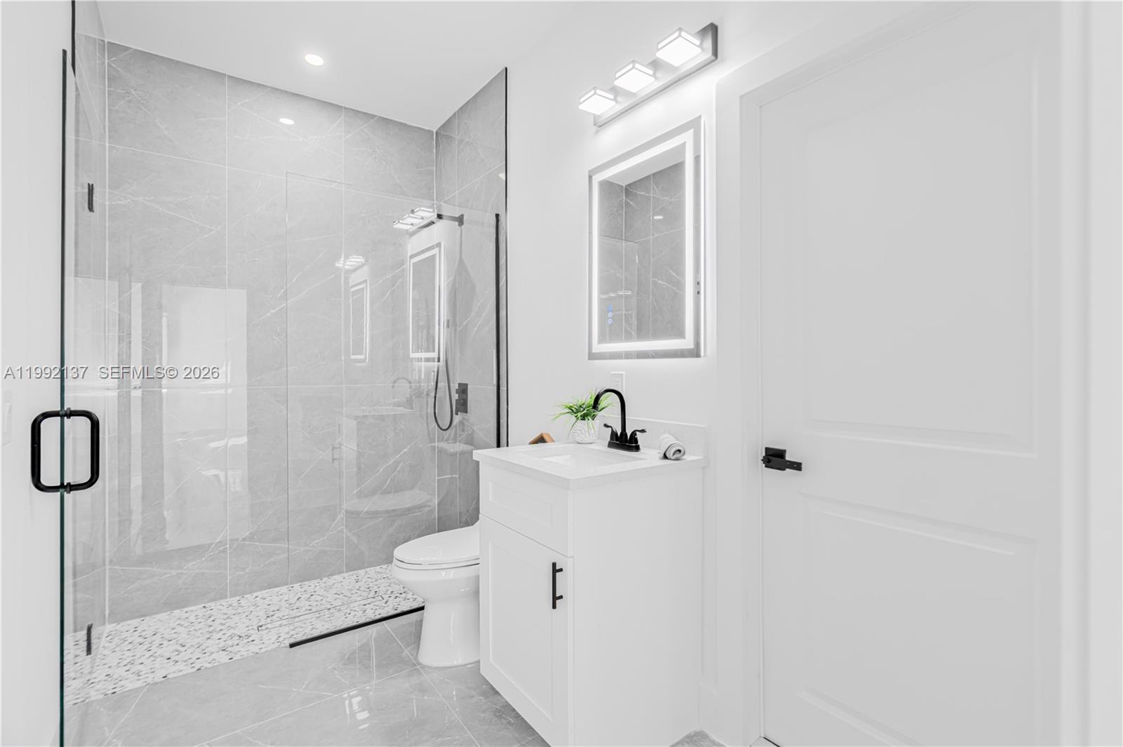 747 Roma Avenue South Lehigh Acres, FL 33974 - Photo 12 of 31 a bathroom with a bathtub shower sink mirror and toilet