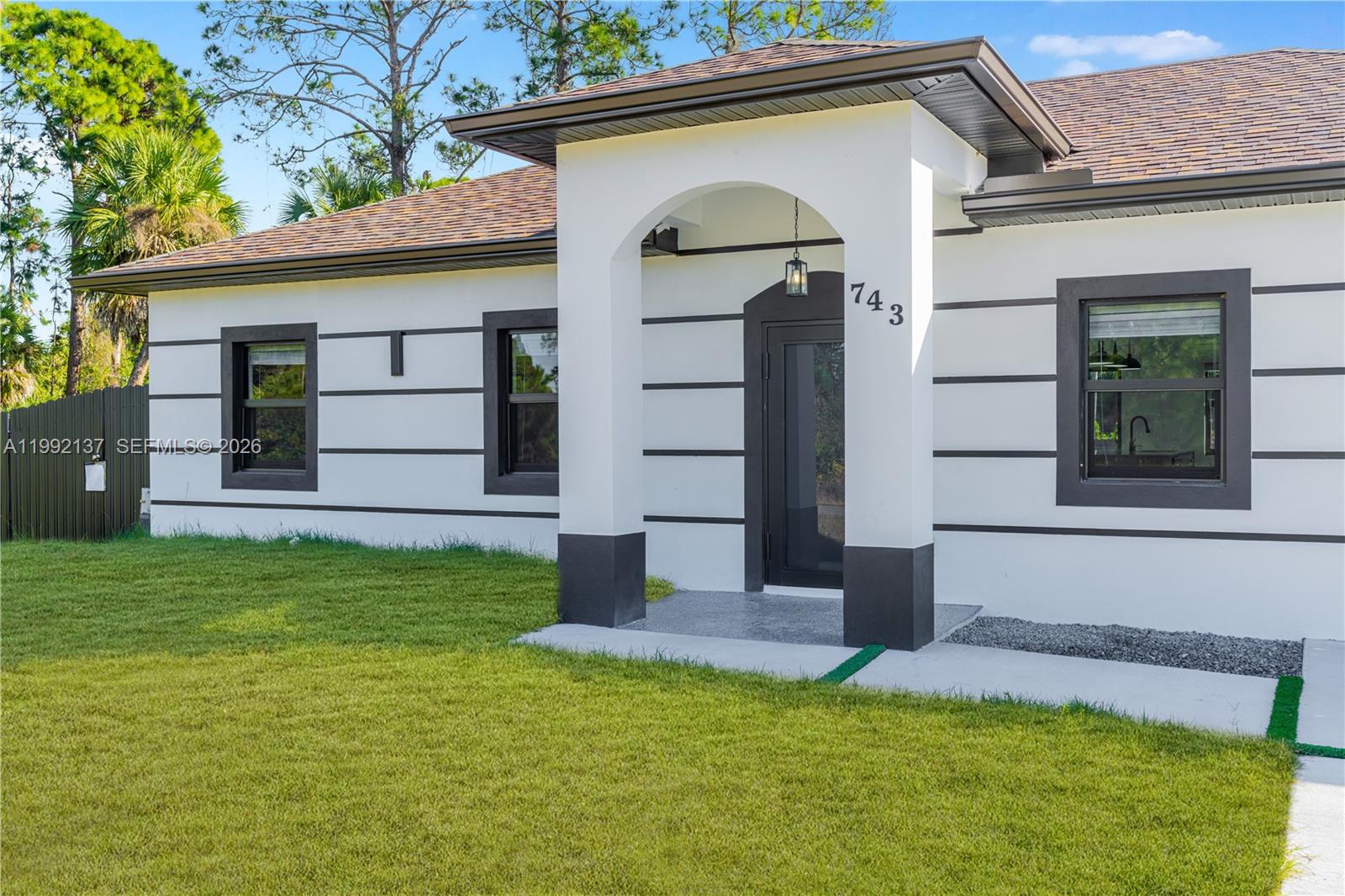 747 Roma Avenue South Lehigh Acres, FL 33974 - Photo 3 of 31 a front view of a house with a yard