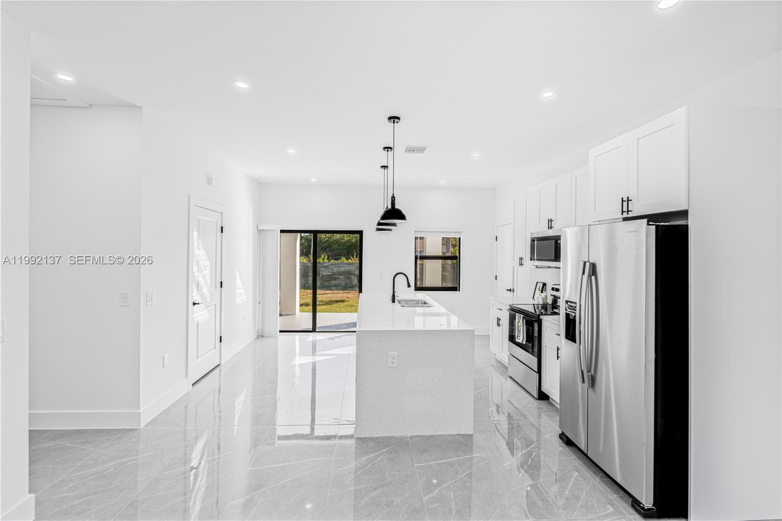 747 Roma Avenue South Lehigh Acres, FL 33974 - Photo 9 of 31 a kitchen with stainless steel appliances granite countertop a refrigerator and a stove top oven