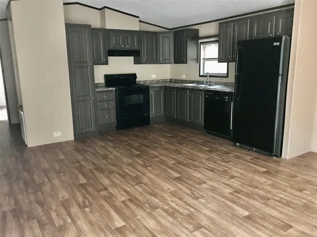 a kitchen with stainless steel appliances granite countertop a stove top oven a sink and dishwasher