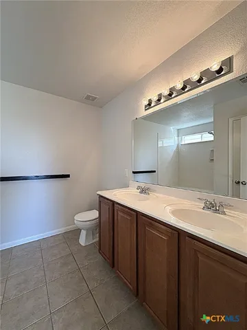a bathroom with a granite countertop sink a toilet and a mirror