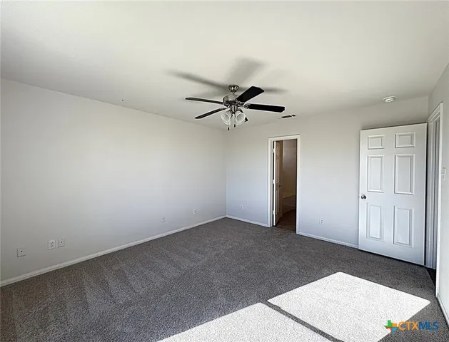 an empty room with a ceiling fan and a window